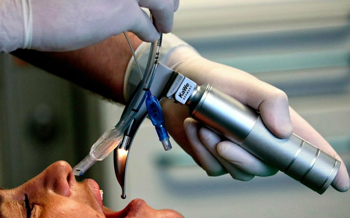 Auf der Intensivstation intubiert ein Arzt einen Patienten Auf der Intensivstation intubiert ein Arzt einen Patienten